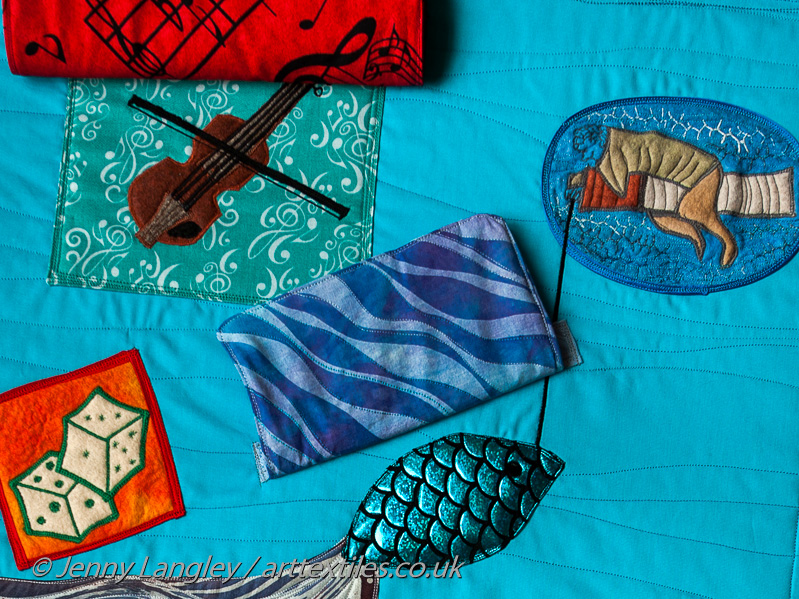 Sailors' pastimes.  Playing music and singing shanties, dice for games such as Uckers and fishing - from a cannon.  The fish and its flap have crinkly fabric.