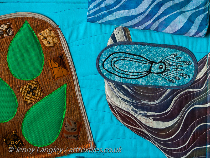 Pocket representing tapa tree bark and leaves with pieces of tapa cloth. The leaves are noisy when scratched. Flap, with crinkly fabric, lifted up to reveal cuttlefish. Large piece of sea and fish fabric used throughout the mat.